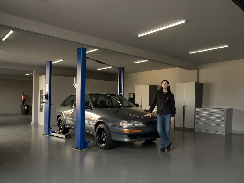 Illustrazione di un'officina con vettura sul ponte sollevatore e armadi attrezzi